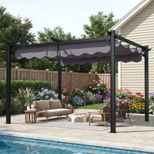 A pergola with a retractable canopy is set up by a pool; it's complemented by outdoor furniture, including a sofa, chairs, a coffee table, and a rug. Lush flower beds and a fence are in the background.