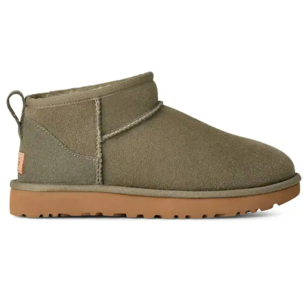 A slip-on, ankle-height boot in olive green with a tan sole and a pull tab, featuring a simple, minimalist design.