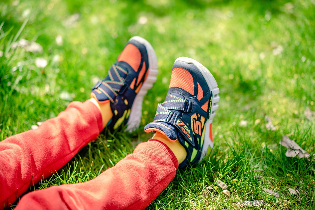 A pair of colorful children's sneakers on grass.