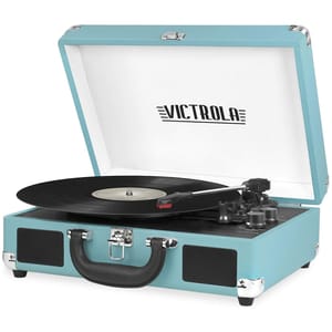 Turquoise Victrola suitcase record player with built-in speakers, displaying a vinyl record on its turntable. The case features a handle and a secure latch for portability.