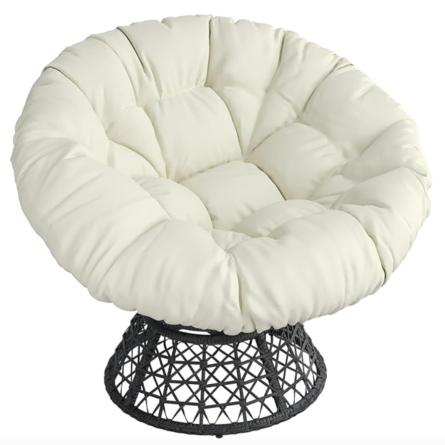 A cream-colored swivel Papasan chair with a round, tufted cushion and a black, woven base.