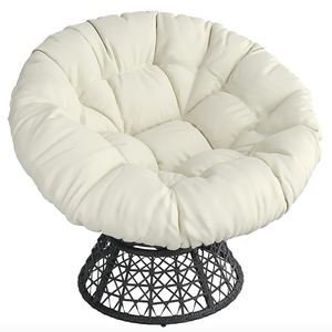 A cream-colored swivel Papasan chair with a round, tufted cushion and a black, woven base.