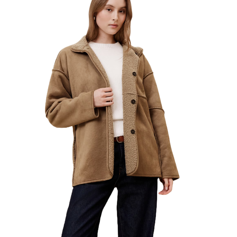 Tan sherpa-lined jacket with button closure, featuring a cozy collar and slightly oversized fit. Paired with a white sweater and dark jeans.