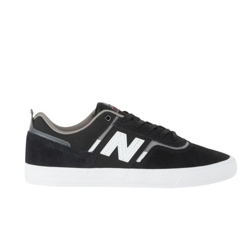 A black and white New Balance sneaker featuring a prominent \“N\“ logo, black suede overlays, and a white sole.