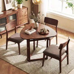 A dining set with a uniquely shaped wooden table and three matching wooden chairs, accompanied by a tea set and a decorative vase, is placed on a textured rug in a well-lit room.