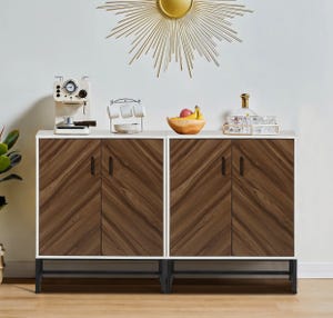 A modern sideboard buffet cabinet with a white frame, dark wood grain doors, and a metal base, featuring a sunburst mirror above and assorted kitchen appliances and decor on top.