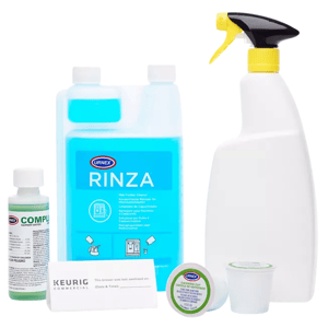 Cleaning supplies for coffee machines, including Urnex Rinza milk frother cleaner, spray bottle, equipment sanitizer, K-Cup cleaning pod, and a sanitation notification card.