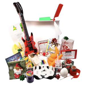 A gift box contains a toy guitar, popcorn, crayons, a Santa-themed item, a plush carrot, slime, a mask with cartoon hands, and various small holiday-themed gifts and novelty items.