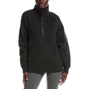 A person is wearing a black half-zip pullover with a kangaroo pocket and gray leggings.