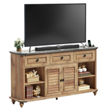 A wooden TV stand features a black flat-screen TV, a soundbar, and decorative items like books, plants, and ornaments on its shelves and drawers.