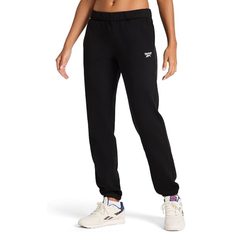 Black Reebok sweatpants with the logo on the left thigh, paired with white Reebok sneakers featuring blue and purple accents.