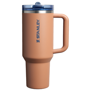Stanley travel mug with a handle in orange-brown color, featuring a blue lid and the Stanley logo.