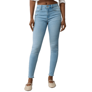 A person is wearing high-waisted light blue skinny jeans and beige flats, paired with a white top.