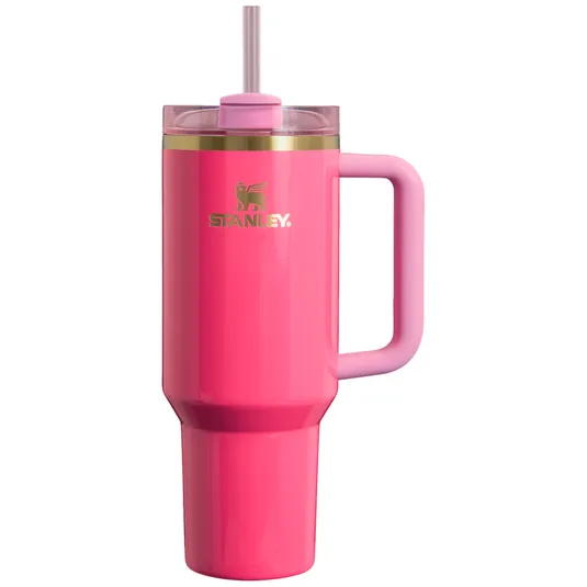 Pink Stanley insulated tumbler with a handle and straw, featuring a gold logo.