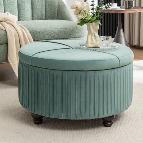 Round teal ottoman with ribbed sides, wooden legs, and a cushioned top, placed in a cozy living room setting.