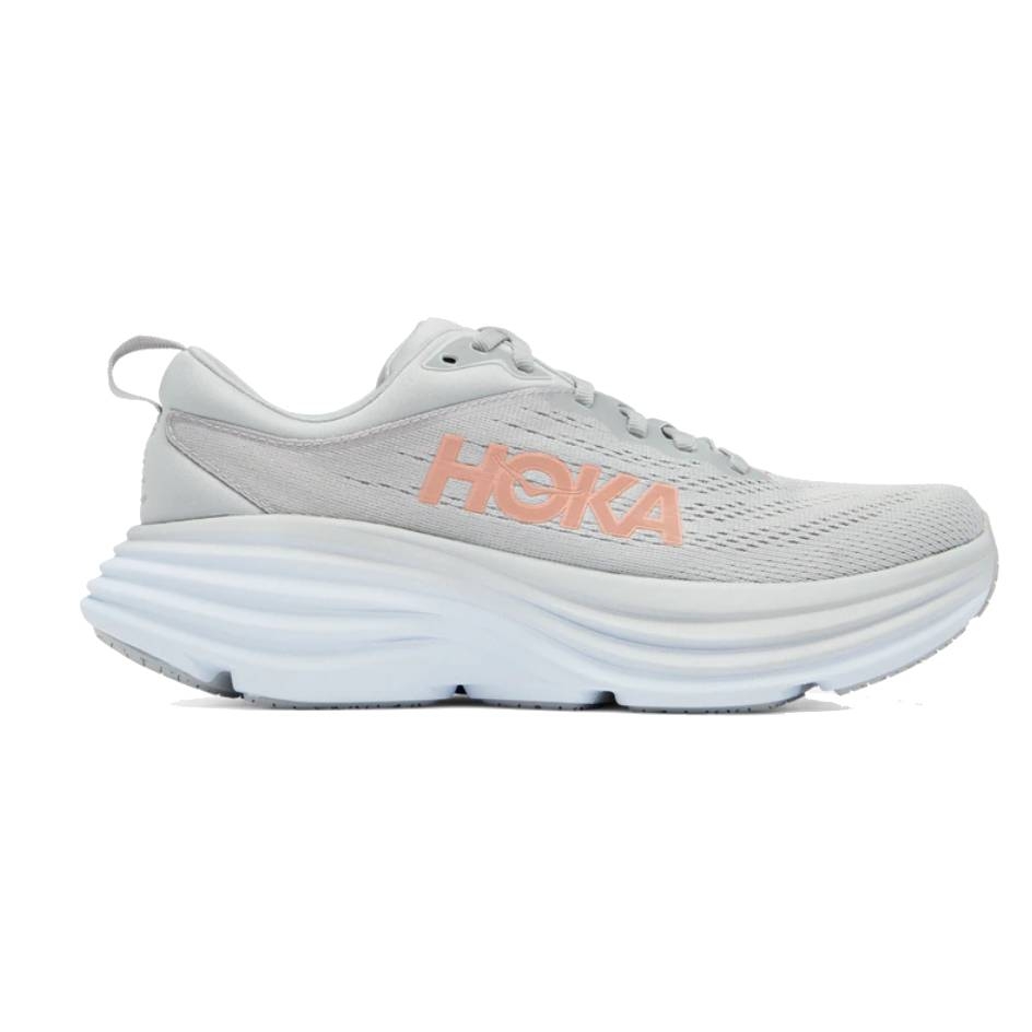Hoka running shoe in light gray with a prominent cushioned sole and \“HOKA\“ branding in pink on the side.