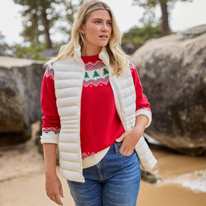 A red holiday sweater with a white quilted vest layered over it, featuring fair isle knit patterns around the collar and cuffs.