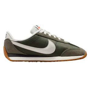 A green and white Nike sneaker with a suede and fabric upper, featuring a prominent white Swoosh logo and a gum sole.