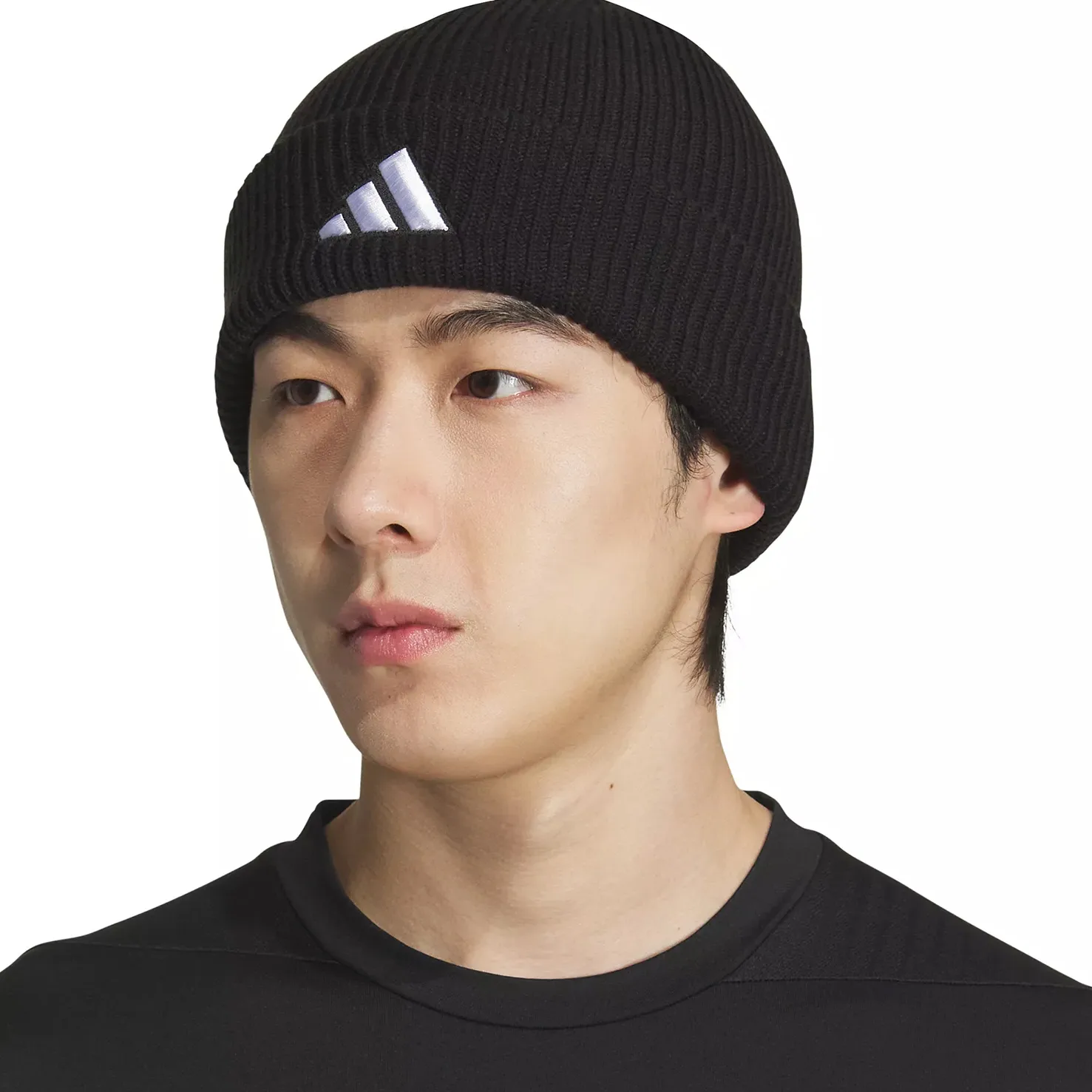 A person wears a black ribbed beanie featuring an Adidas logo and a black crew-neck shirt.