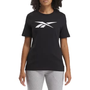 A woman is wearing a black Reebok t-shirt with a large white logo on the front, paired with gray pants.