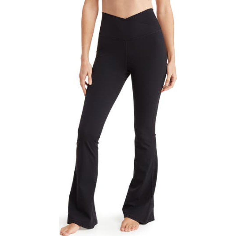 Black crossover flared leggings with a high-waisted design featuring a V-shaped waistband. The pants have a snug fit through the thighs and flare out towards the ankles.