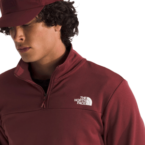 A person wearing a maroon North Face pullover with a quarter-zip and a matching cap.