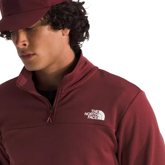 A person wearing a maroon North Face pullover with a quarter-zip and a matching cap.