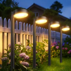 Outdoor landscape lights illuminate a garden, positioned along a white picket fence with blooming hydrangeas.