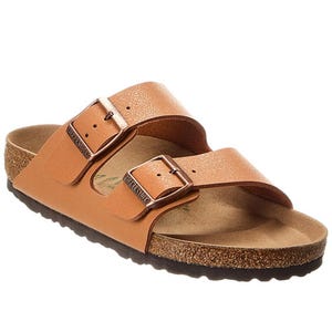 Birkenstock Arizona Birko-Flor Sandals feature two adjustable straps in a tan, leather-like material with metal buckles, a contoured cork footbed, and a black rubber outsole for comfort and support.