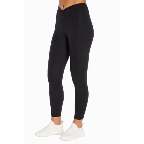 Black leggings with a high-waist and crossover waistband, paired with white sneakers.