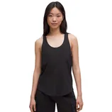 A woman is wearing a black sleeveless tank top with a scoop neck and black cargo pants.