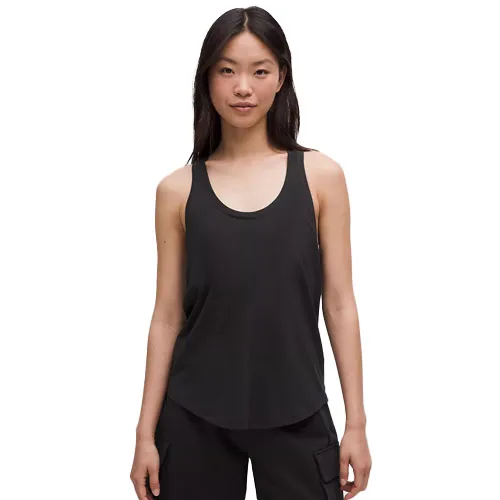 A woman is wearing a black sleeveless tank top with a scoop neck and black cargo pants.