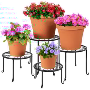 Four black metal plant stands of varying heights with round tops, each holding a terracotta pot with colorful flowers.