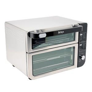 A Ninja stainless steel dual-compartment countertop oven with digital controls, featuring two stacked doors and a control panel on the side.