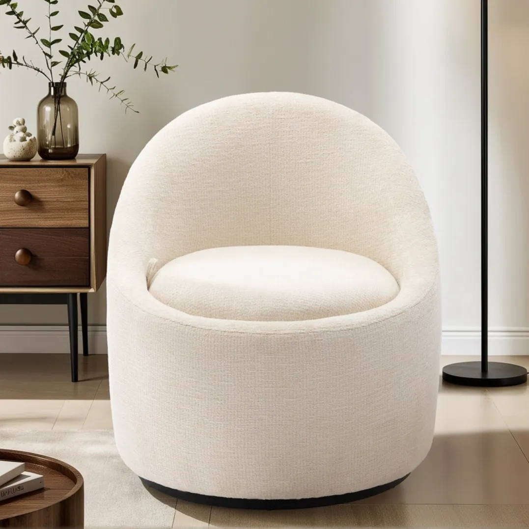 A cozy, round, cream-colored swivel chair sits next to a modern wooden side table with vases and a floor lamp, on a light wood floor.