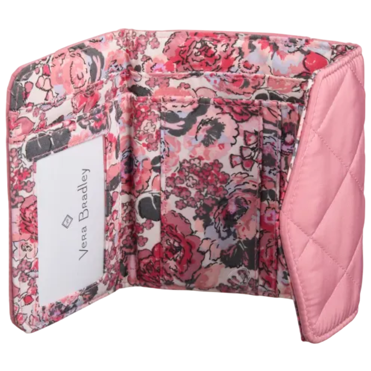 A pink quilted wallet with a floral design interior, featuring multiple card slots and an ID window labeled \“Vera Bradley.\“