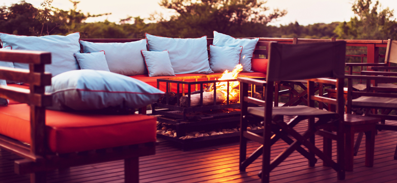 Outdoor patio furniture set with fire pit table in backyard setting. Add warmth and ambiance with this stylish patio focal point.