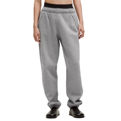 Gray oversized joggers with an elastic waistband, side pockets, and gathered ankles, paired with black shoes.