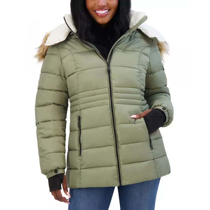 A woman wears a green Steve Madden puffer coat with a faux fur-lined hood, zippered front, and ribbed cuffs.