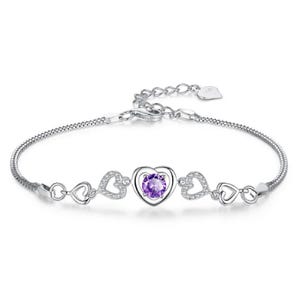 A silver bracelet featuring a central purple heart-shaped gemstone surrounded by hollow heart-shaped designs, some with embedded crystals.