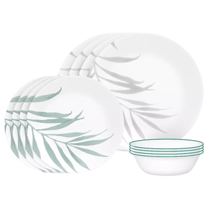 A dinnerware set with a nature-inspired design, featuring plates with a leaf pattern and bowls with green rims.