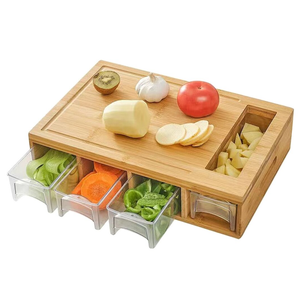 A bamboo cutting board with built-in storage trays underneath holds different sliced vegetables. It includes compartments for easy organizing and prepping, with slots for collecting and storing food.