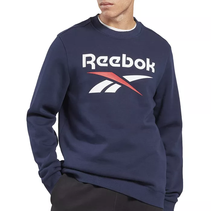 A navy blue Reebok Identity Logo sweatshirt featuring the Reebok logo in white and red across the chest, with long sleeves and a ribbed crew neck collar.