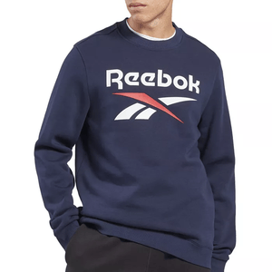 A navy blue Reebok Identity Logo sweatshirt featuring the Reebok logo in white and red across the chest, with long sleeves and a ribbed crew neck collar.