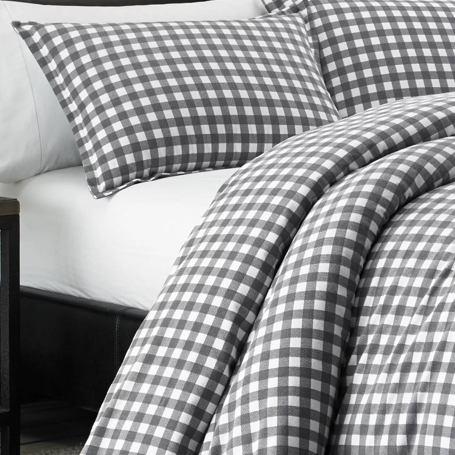 Gray and white checkered bedding set with pillowcases and a comforter on a neatly made bed.