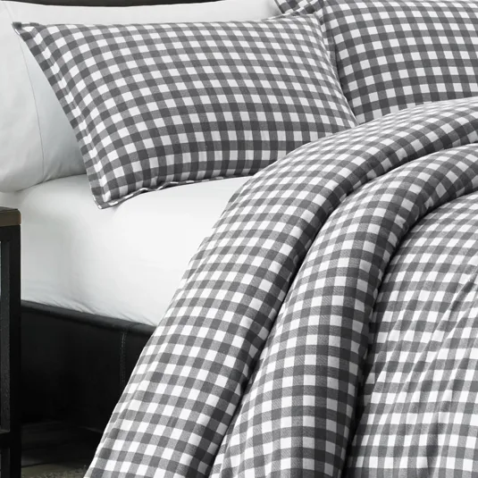 Gray and white checkered bedding set with pillowcases and a comforter on a neatly made bed.