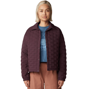 A person is wearing a quilted burgundy jacket over a blue graphic T-shirt, paired with brown pants, against a neutral background.