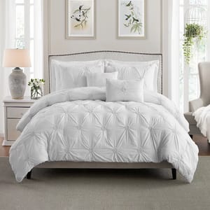This is a white pintuck comforter set featuring a decorative pattern of raised, pinched fabric in a symmetrical design, complete with matching pillow shams.