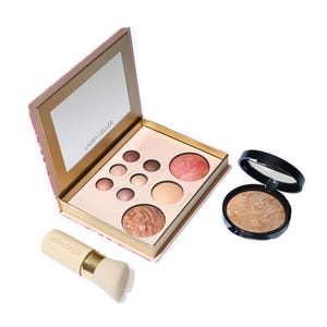 A makeup palette with various shades and a single compact with a brush.