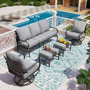 Outdoor patio furniture set including a sofa, two rocking chairs, and two square tables with cushions on a patterned rug.